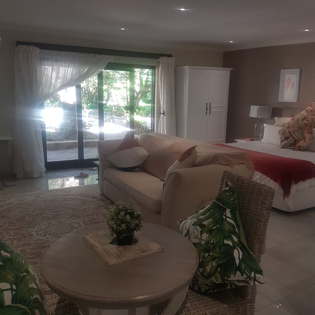 Guest suite with double bed and lounge chairs